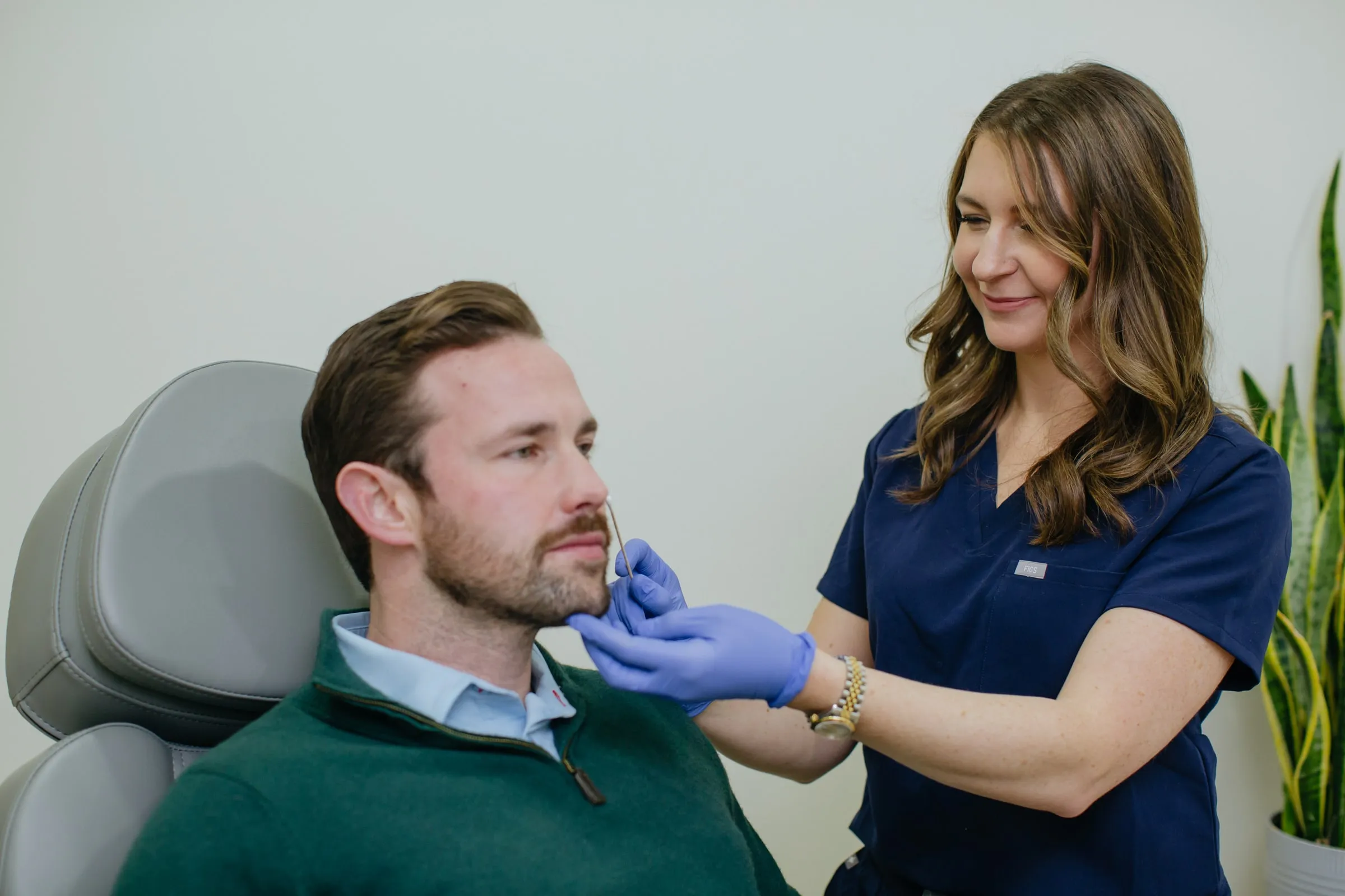 Danielle Wise, NP, treating a seated male patient in the treatment room