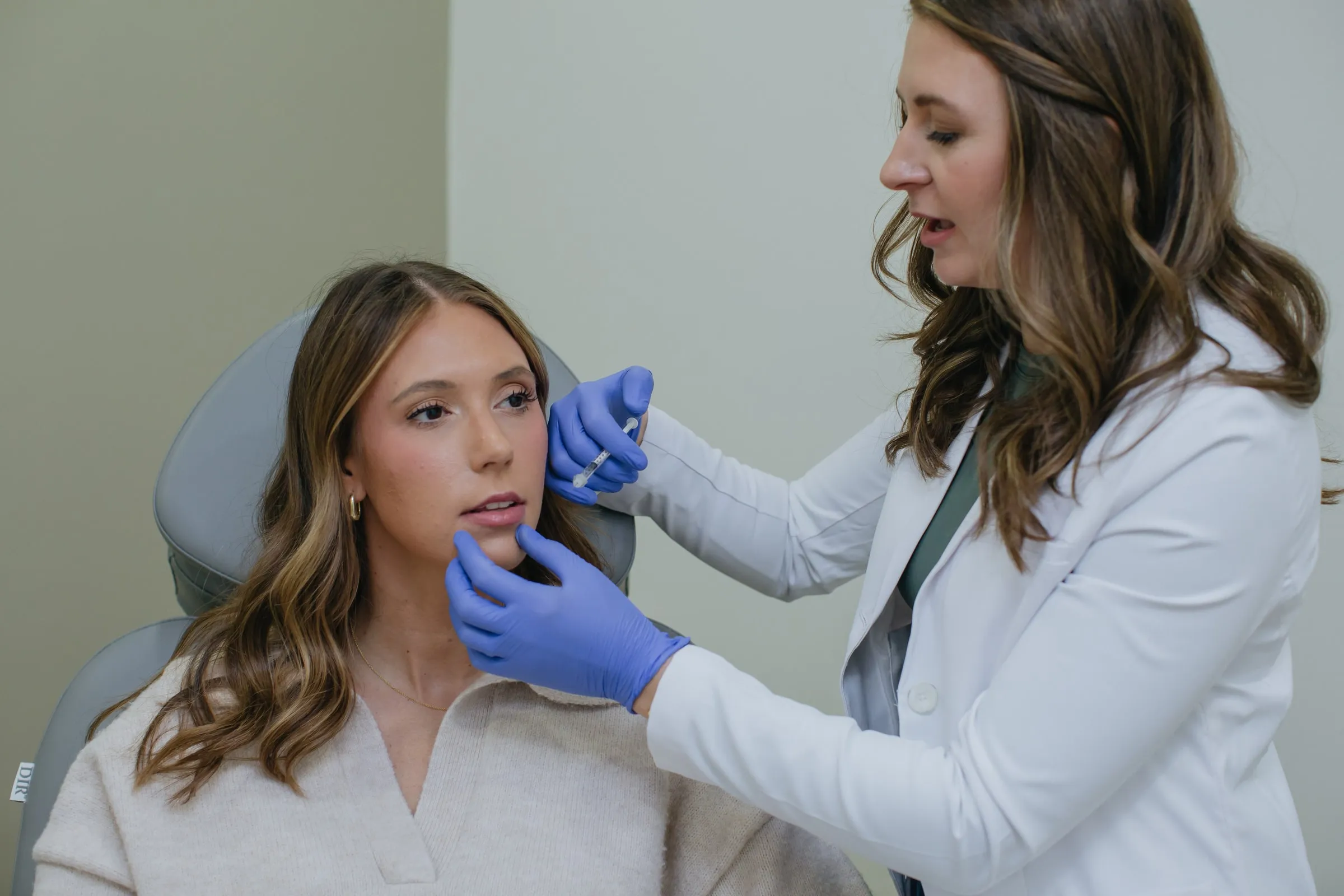 Danielle Wise, NP, performing a facial treatment on a seated patient