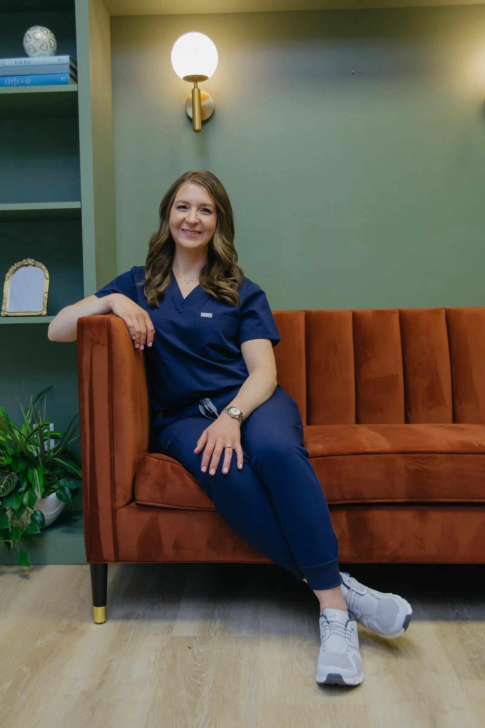 Danielle Wise, NP, seated on a velvet sofa in the Espe space